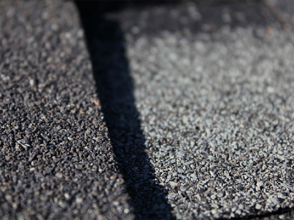 Close detail of asphalt shingle granules and the shingle keyway