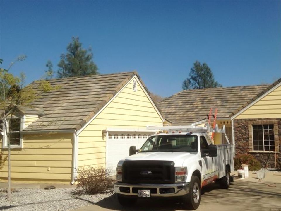 Completed roof on a yellow Redding home with the Sunrise Roofing truck on site
