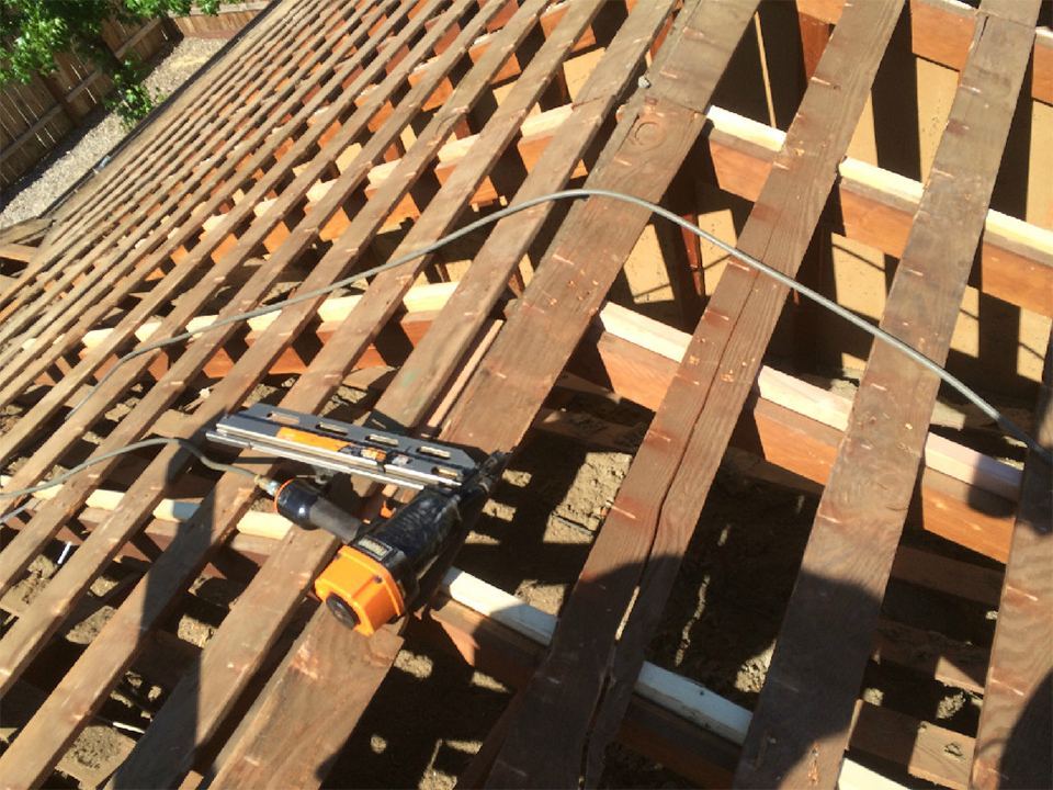 Roof stripped to bare rafters and skip sheathing during dry rot repair